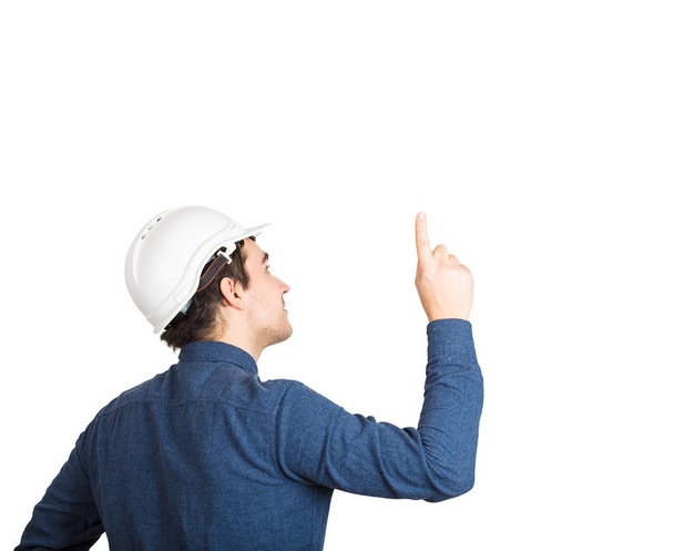 Takana näkymä nuori mies insinööri yllään suojakypärä osoittaa etusormella ylös eristetty valkoisella pohjalla kopioi tilaa
. - Valokuva, kuva
