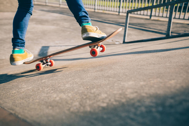 Cropped shot of skateboarder skateboarding at skatepark ramp - Zdjęcie, obraz