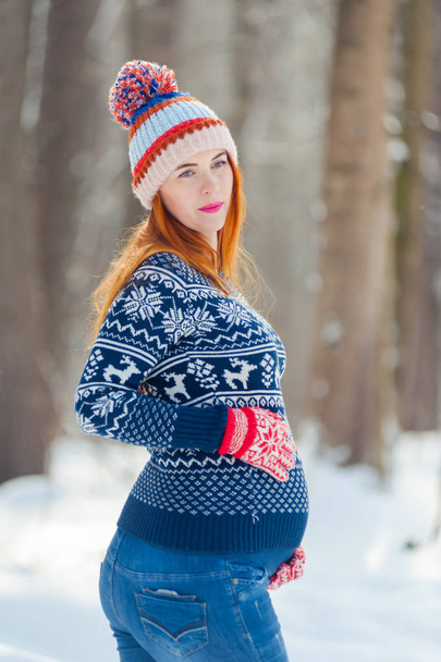 Beautiful pregnant woman in winter forest - 写真・画像