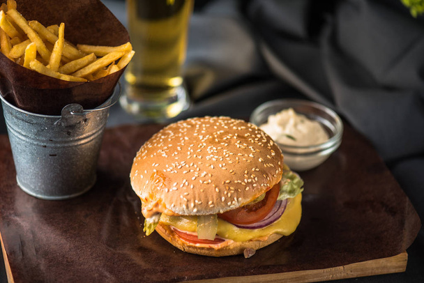 Tasty burger with french fries on wooden board - Photo, Image