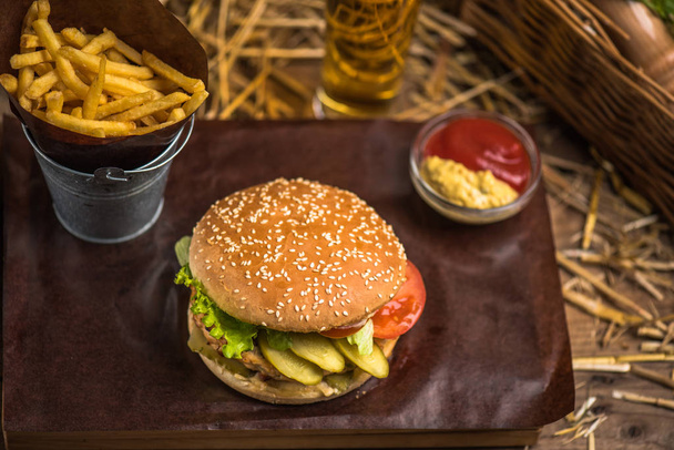 Tasty burger with french fries on wooden board - Fotó, kép