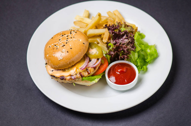 Burger with french fried and ketchup served on white plate - Фото, изображение