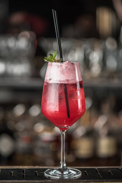 Pink cocktail with straw in glass on bar counter - Zdjęcie, obraz