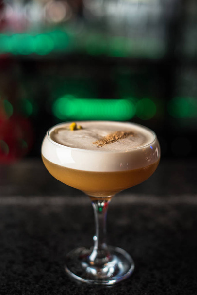 close-up of sour cocktail in glass on dark blurred background - Foto, Imagem