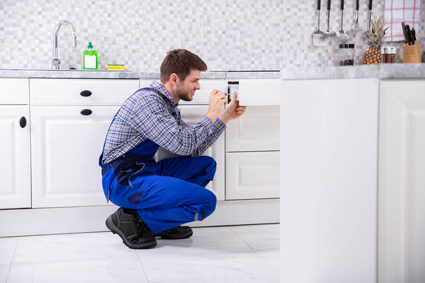 Close-up Of A Male Carpenter Installing Door Of Drawer In The Kitchen - 写真・画像