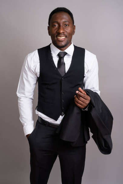 Joven hombre de negocios africano guapo sobre fondo gris - Foto, Imagen
