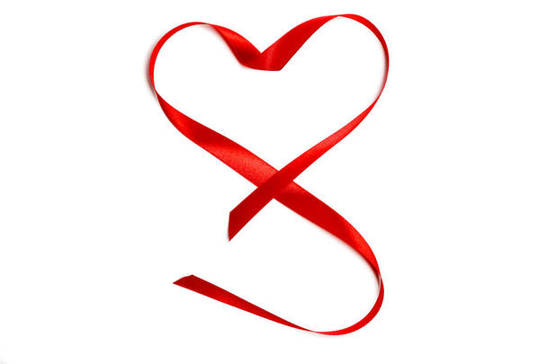 Vértes piros szatén szalaggal vagy szalag, szív alakú elszigetelt fehér background. Koncepció Valentin-napot, házassági évforduló, nászút, ifjú szerelmesek - Fotó, kép
