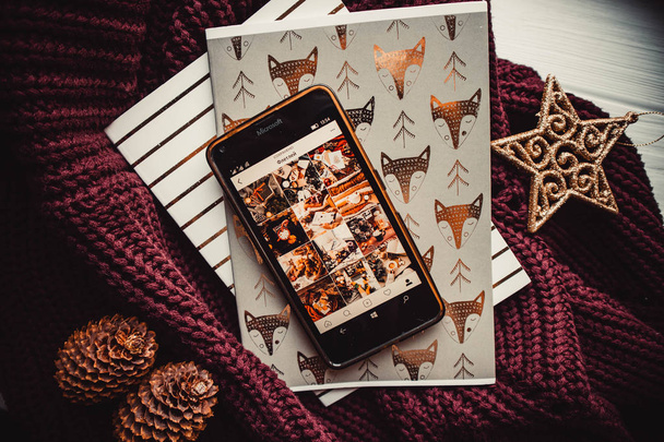 Phone and notepads on wood background with christmas decorations - Foto, Imagen