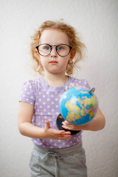 A Little Girl Studying The Globe. concepto de educación
 - Foto, imagen