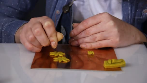 Close-up van geschoolde vrouw kunstenaar maken handgemaakte sieraden van polymeerklei op de tafel in haar atelier. - Video