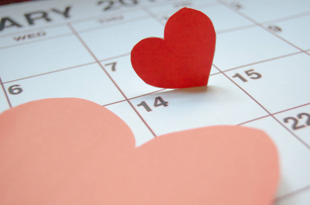 Paper red hearts marking 14 february Valentines day on white calendar - Valentines's day concept - Foto, imagen