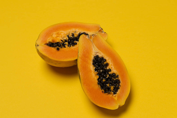 Τροπικά φρούτα εποχής, τοπική αγορά μισό φρέσκο ώριμο papaya σε κίτρινο φόντο, το top view, επίπεδη lay, αντίγραφο χώρου - Φωτογραφία, εικόνα