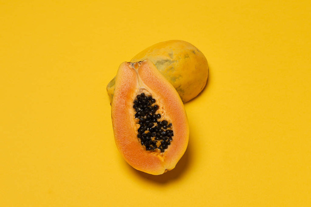Seasonal tropical fruit, local market half fresh ripe papaya on yellow background, top view, flat lay, copy space - Valokuva, kuva