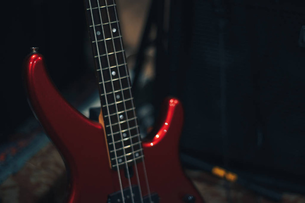Red bass guitar on a home musical studio background. - Fotoğraf, Görsel