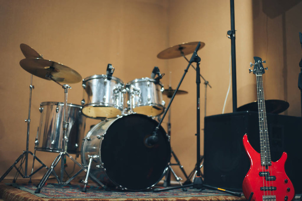 Červené basová kytara na pozadí domácí hudební studio. - Fotografie, Obrázek