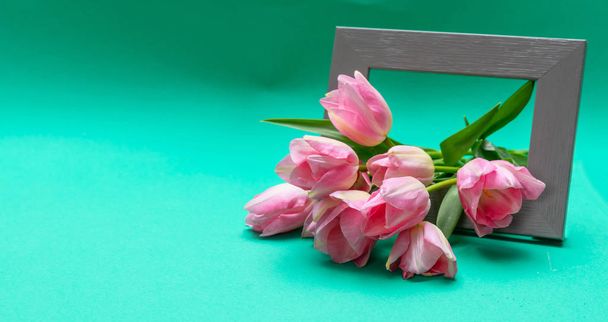 Матери, женский день. Букет розовых тюльпанов из деревянной рамы, зеленый фон, пространство для копирования
 - Фото, изображение