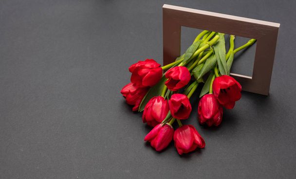 День святого Валентина концепция. Букет из красных тюльпанов из деревянной рамы, темно-серый фон, пространство для копирования
 - Фото, изображение