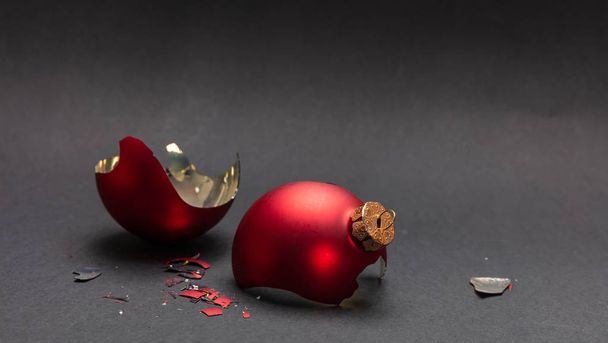 Incidente di Natale. Palla di Natale rossa rotta, sfondo grigio scuro, vista da vicino
 - Foto, immagini
