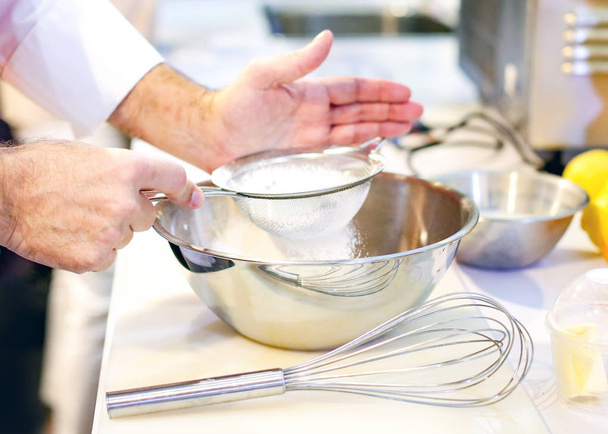 Przesiewanie mąki do miski w kuchni piekarnia piekarz - Zdjęcie, obraz