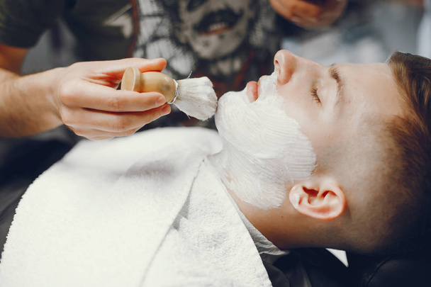 The man cuts his beard in the barbershop - Foto, Bild