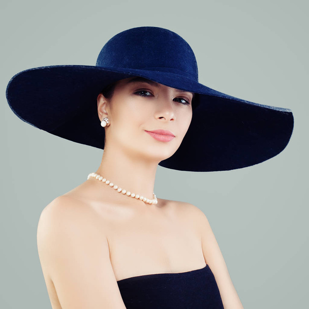 Mulher atraente em chapéu clássico azul e pérolas brancas, retrato de moda
 - Foto, Imagem