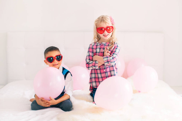 Portret grupy szczęśliwy Kaukaska cute adorable śmieszne dzieci w okularach kształt serca. Chłopak i dziewczyna z różowy balony. Miłość, przyjaźń i zabawy. Valentine dzień świąteczny. - Zdjęcie, obraz