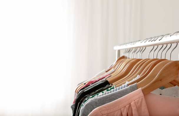 Wardrobe rack with stylish clothes indoors, closeup. Space for text - 写真・画像