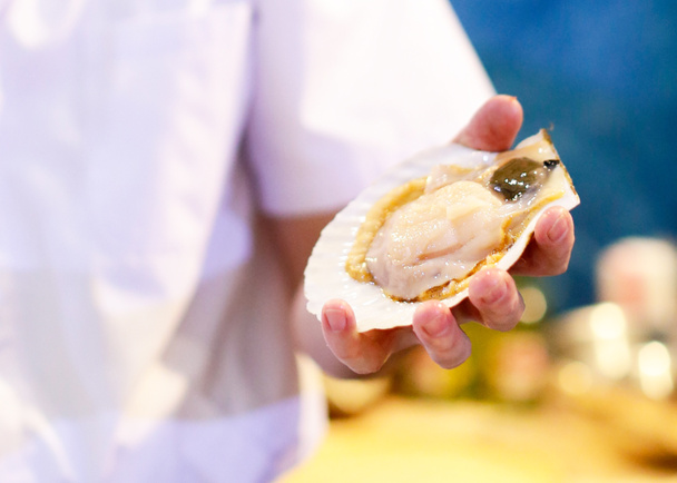 frische Austern auf Hand, saubere und offene rohe Austern - Foto, Bild