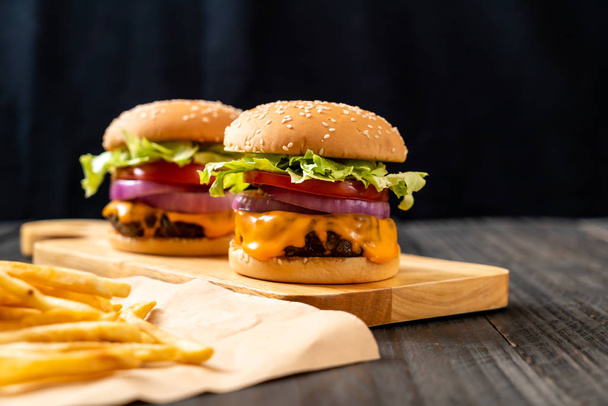 fresh tasty beef burger with cheese and french fries on wood background - Fotó, kép