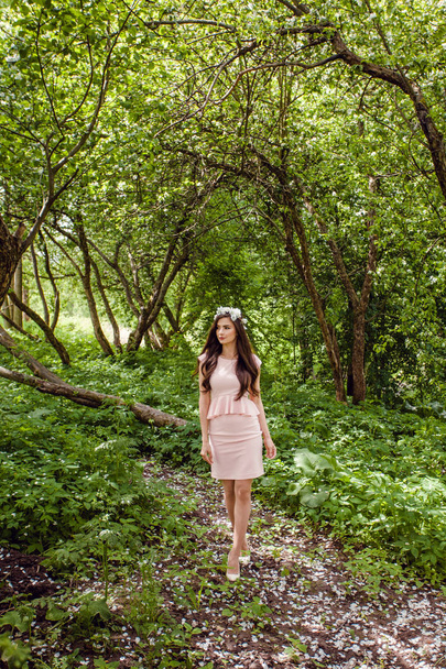 Cute młoda kobieta w różowej sukience stojący na zewnątrz ogród kwiaty. Piękna dziewczyna odkryty portret - Zdjęcie, obraz