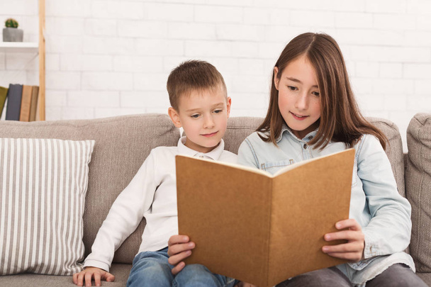 Bratr a sestra čtení knihy na pohovce - Fotografie, Obrázek