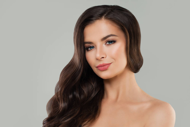 若い笑顔の女性スパ モデル健康な肌と長い巻き毛。ヘアケアとスキンケアの背景 - 写真・画像