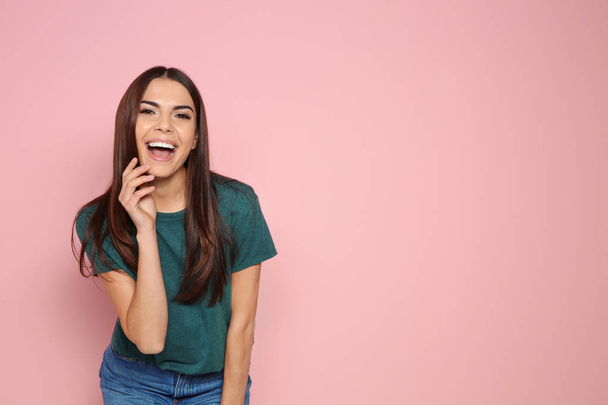 Portrait of young woman laughing on color background. Space for text - Fotó, kép