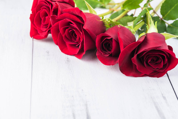 Close up of red roses for holidays on a wooden background. Copy space. - Foto, afbeelding