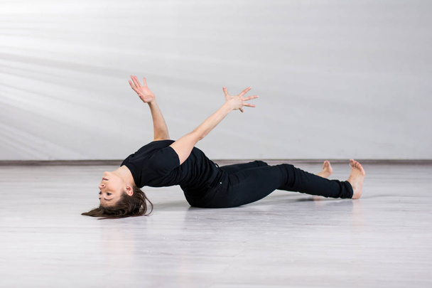 Танцовщица лежит на сером фоне
. - Фото, изображение
