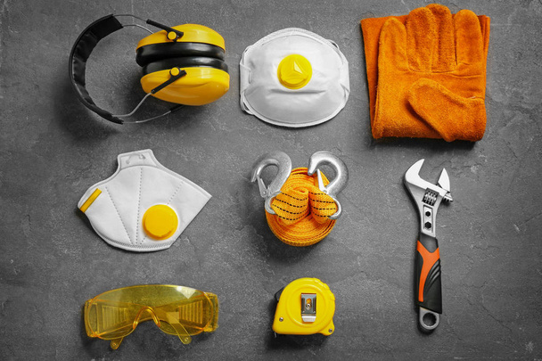 Flat lay composition with tools and safety equipment on grey background - Foto, Imagen