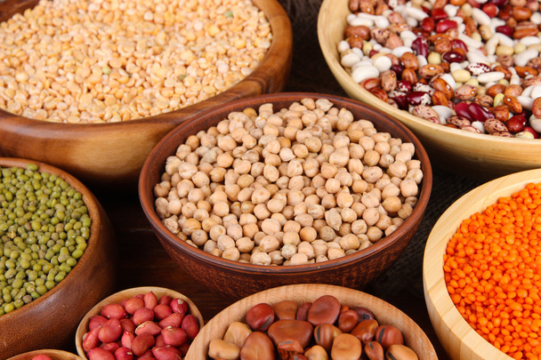 Different kinds of beans in bowls on wooden background - Φωτογραφία, εικόνα