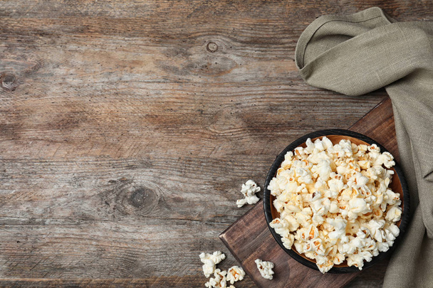 Flat lay composition with popcorn and space for text on wooden background - Valokuva, kuva