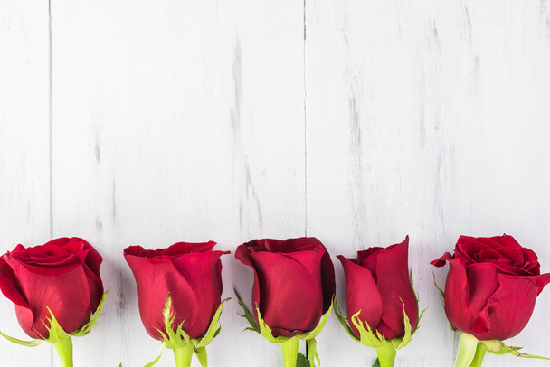 Close up of red roses for Valentines Day on a wooden background. Copy space. - Фото, изображение