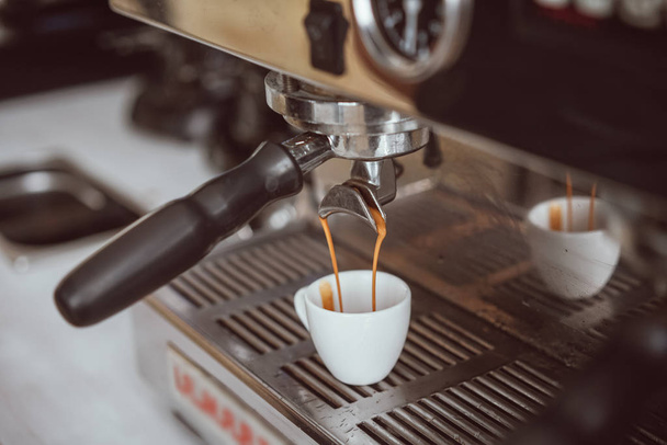 Professionele espressomachine verse koffie gieten in witte keramische cup - Foto, afbeelding