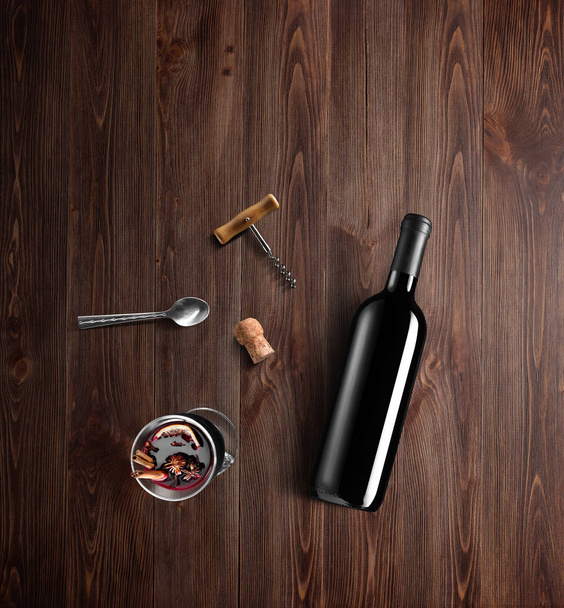 Mulled wine recipe ingredients and kitchen accessories, bottle of red wine, cinnamon, anise stars, orange, brown sugarand spice on rustic wood background. - 写真・画像
