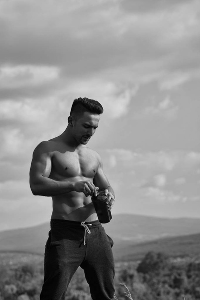 muscular man posing with water bottle - Foto, Imagen