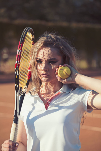 Woman hold racket and ball on lawn. Sensual woman on tennis court. Tennis player training on sunny outdoor. Sportswoman in fashion sportswear on court. Sport activity and wellness concept - Foto, Imagem