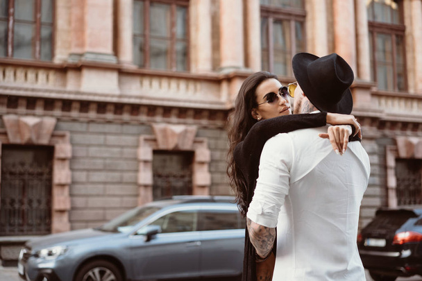 Una joven y sexy pareja de amantes posan para una cámara en las calles
 - Foto, Imagen