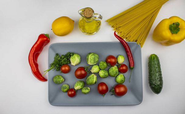 Fondo alimenticio. aislar Varios ingredientes culinarios con espaguetis y verduras y mantequilla. Vista superior con espacio de copia
. - Foto, imagen