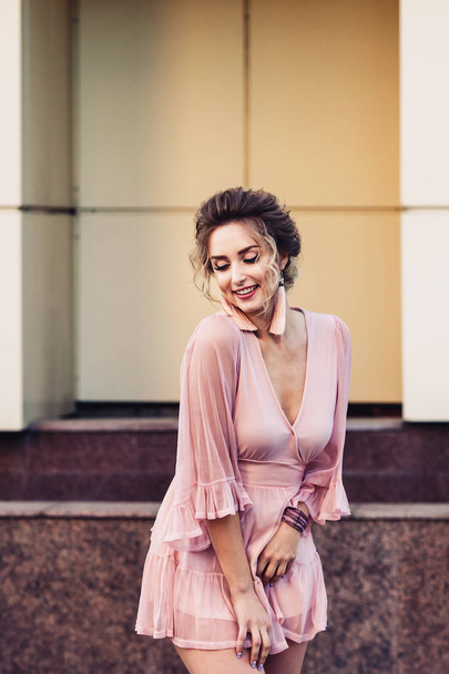 attraente ragazza in un breve abito rosa in posa vicino a un bellissimo edificio
. - Foto, immagini