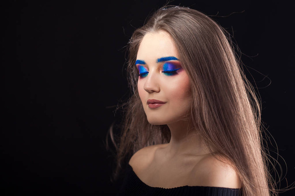 Attractive brunette with bright stylish make-up. Colored Smokey eyes and blue eyebrows. - Foto, Imagem