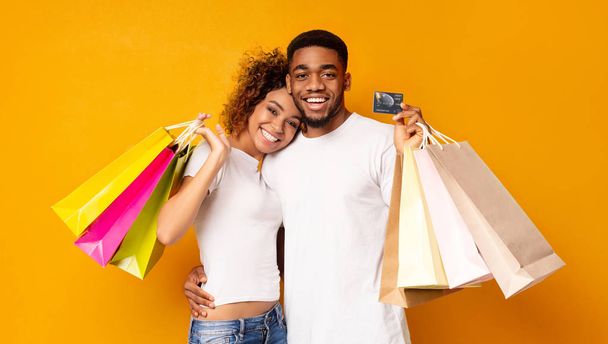 Joven pareja negra con bolsas de compras y tarjeta de crédito
 - Foto, Imagen