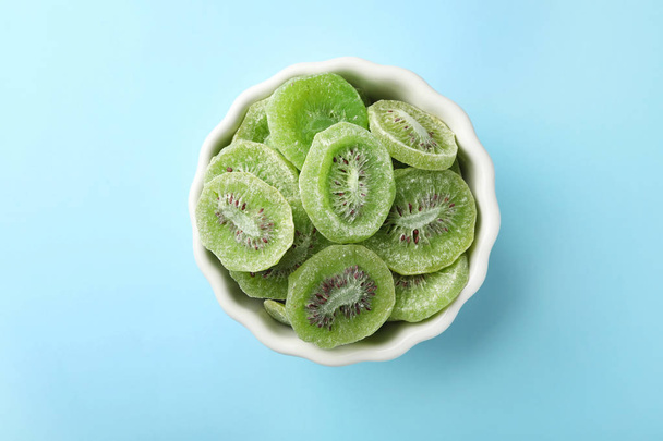 Bowl with slices of kiwi on color background, top view. Dried fruit as healthy food - Φωτογραφία, εικόνα