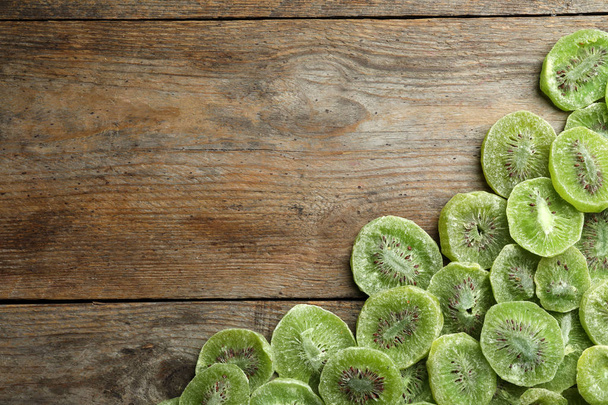 Frame made of kiwi on wooden background, top view with space for text. Dried fruit as healthy food - Foto, immagini
